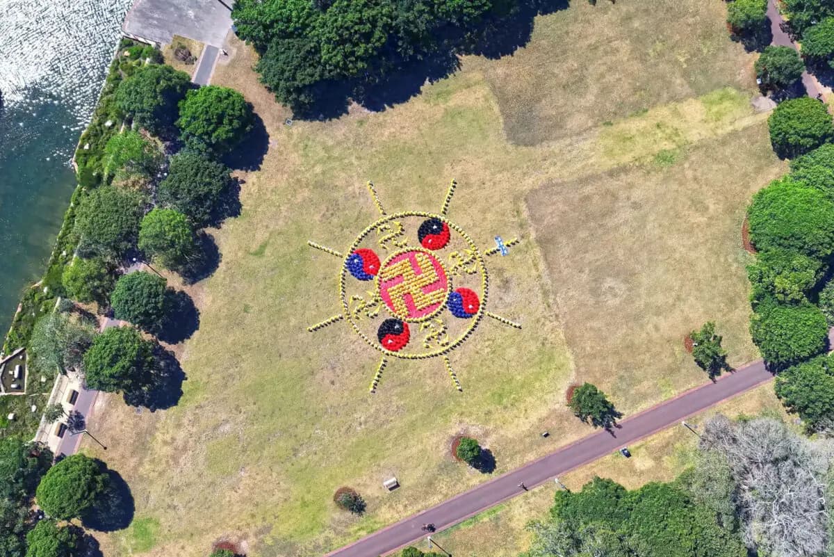 Los practicantes de Falun Gong, vestidos con trajes coloridos a juego, formaron un gigantesco patrón de Falun en el Jubilee Park, Sídney, Australia, el 11 de octubre de 2025. (Wang Nan/NTD TV).
