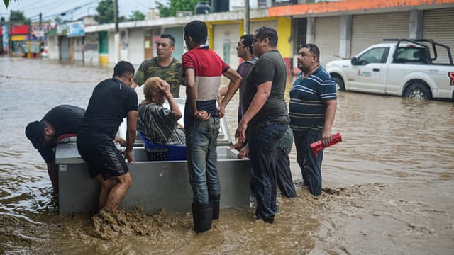 Hombres usan un refrigerador para rescatar a una mujer de las inundaciones en Poza Rica, Veracruz, México, el 10 de octubre de 2025. Las fuertes lluvias del 9 de octubre de 2025 en México han causado muertes, además de inundaciones de viviendas, deslizamientos de tierra y el desbordamiento de ríos en varias partes del país, informó el gobierno de México el viernes. (Foto de MARCO ANTONIO PEREZ/AFP vía Getty Images)