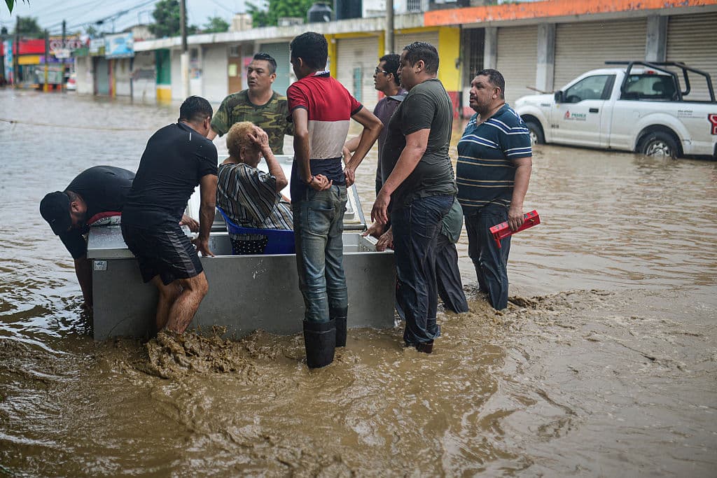 Hombres usan un refrigerador para rescatar a una mujer de las inundaciones en Poza Rica, Veracruz, México, el 10 de octubre de 2025. Las fuertes lluvias del 9 de octubre de 2025 en México han causado muertes, además de inundaciones de viviendas, deslizamientos de tierra y el desbordamiento de ríos en varias partes del país, informó el gobierno de México el viernes. (Foto de MARCO ANTONIO PEREZ/AFP vía Getty Images)