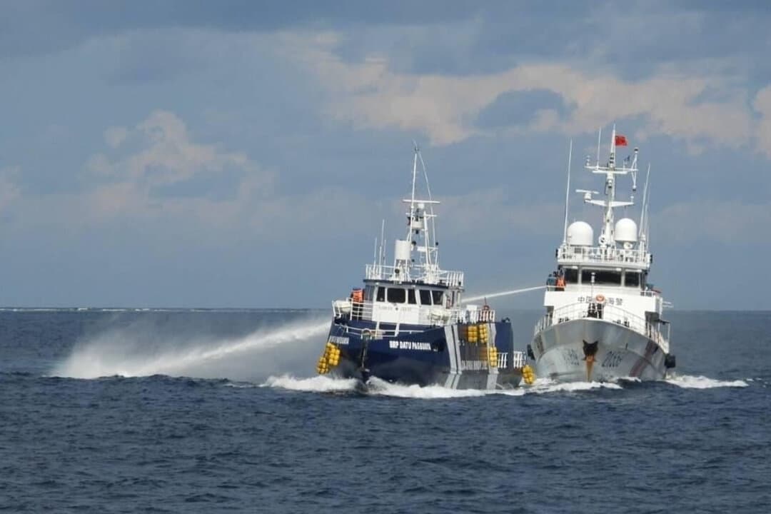 Un barco de la guardia costera china (derecha) dispara su cañón de agua contra el BRP Datu Pagbuaya de Filipinas cerca de la isla de Thitu, ocupada por Filipinas y conocida localmente como isla Pag-asa, en el mar de la China Meridional, el 12 de octubre de 2025. (Guardia Costera de Filipinas vía AP)
