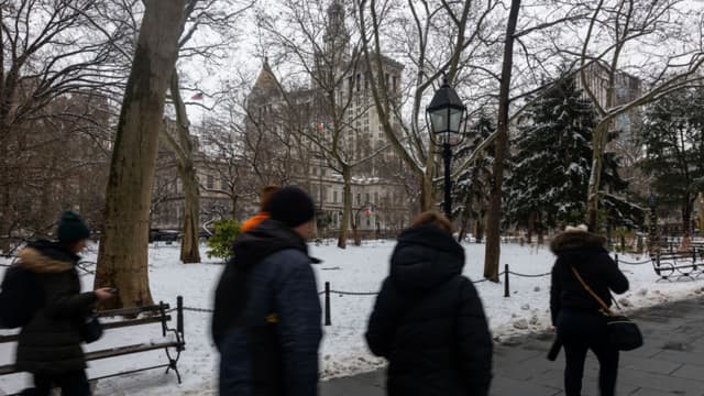 NEW YORK, NEW YORK - FEBRUARY 12:  People walk through City Hall Park after a snow storm in Manhattan on February 12, 2025 in New York City. The metro area received up to three inches of snow with more expected this evening as much of the Northeast experiences cold temperatures.  (Photo by Spencer Platt/Getty Images)