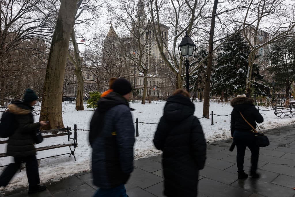 NEW YORK, NEW YORK - FEBRUARY 12:  People walk through City Hall Park after a snow storm in Manhattan on February 12, 2025 in New York City. The metro area received up to three inches of snow with more expected this evening as much of the Northeast experiences cold temperatures.  (Photo by Spencer Platt/Getty Images)