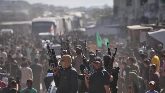 Hombres armados de Hamás en camionetas escoltan autobuses que transportan a prisioneros palestinos liberados mientras son recibidos tras su liberación de las cárceles israelíes en virtud de un acuerdo de alto el fuego entre Hamás e Israel, en Jan Yunis, al sur de la Franja de Gaza, el 13 de octubre de 2025. (Jehad Alshrafi/AP Photo)
