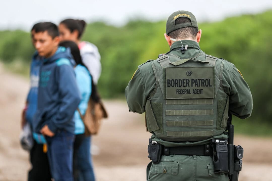 Un agente de la Patrulla Fronteriza de Estados Unidos detiene a inmigrantes indocumentados que acaban de cruzar el Río Grande desde México hacia Peñitas, Texas, el 21 de marzo de 2019. (Charlotte Cuthbertson/The Epoch Times)