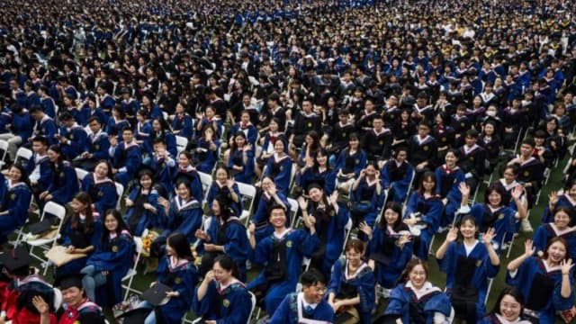 Casi 11,000 graduados, incluyendo a más de 2000 estudiantes que no pudieron asistir a la ceremonia de graduación el año anterior debido al COVID-19, asisten a una ceremonia de graduación en la Universidad Normal Central de China en Wuhan, en la provincia central china de Hubei, el 13 de junio de 2021. (STR/AFP vía Getty Images)