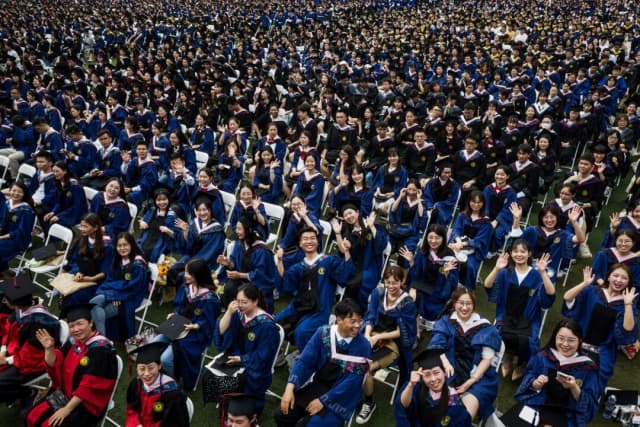 Casi 11,000 graduados, incluyendo a más de 2000 estudiantes que no pudieron asistir a la ceremonia de graduación el año anterior debido al COVID-19, asisten a una ceremonia de graduación en la Universidad Normal Central de China en Wuhan, en la provincia central china de Hubei, el 13 de junio de 2021. (STR/AFP vía Getty Images)
