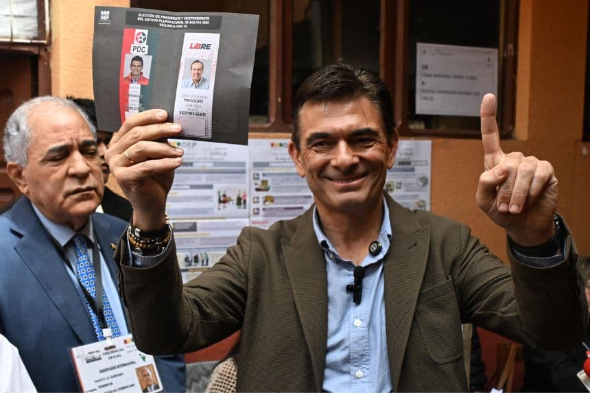 El candidato presidencial de Bolivia por el Partido Demócrata Cristiano (PDC), Rodrigo Paz, muestra su papeleta junto al observador internacional de la República Dominicana, Fausto Liz Quiñones, antes de votar en un colegio electoral durante la segunda vuelta de las elecciones presidenciales en Tarija, Bolivia, el 19 de octubre de 2025. (Foto de AIZAR RALDES/AFP vía Getty Images)