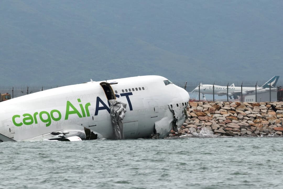Un avión de carga yace parcialmente en el mar tras salirse de la pista durante el aterrizaje en el Aeropuerto Internacional de Hong Kong, el 20 de octubre de 2025. (Tyrone Siu/Reuters)