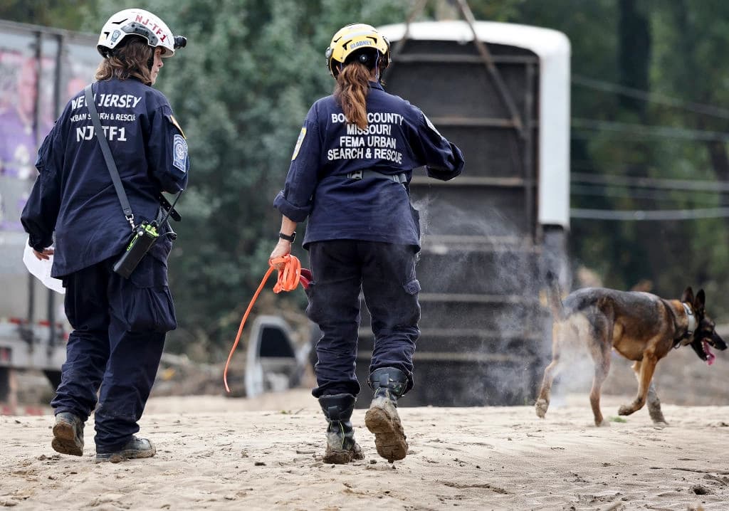 Miembros del Grupo de Trabajo de Búsqueda y Rescate Urbano de la FEMA registran una zona afectada por las inundaciones con un perro de búsqueda tras el paso del huracán Helene a lo largo del río Swannanoa en Asheville, Carolina del Norte, el 4 de octubre de 2024. (Mario Tama/Getty Images)