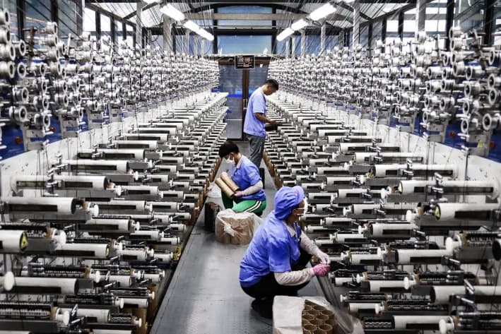 Empleados trabajando en una línea de producción de fibra de carbono en Lianyungang, provincia de Jiangsu, China, el 31 de julio de 2025. Uno de los objetivos clave del Partido Comunista Chino es lograr la autosuficiencia tecnológica. (STR/AFP a través de Getty Images)