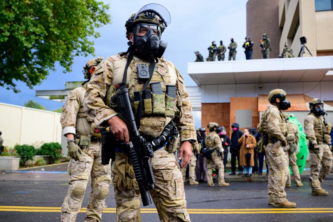Agentes federales se enfrentan con manifestantes en el edificio del Servicio de Inmigración y Control de Aduanas de Estados Unidos en Portland, Oregón, el 12 de octubre de 2025. (Mathieu Lewis-Rolland/Getty Images)