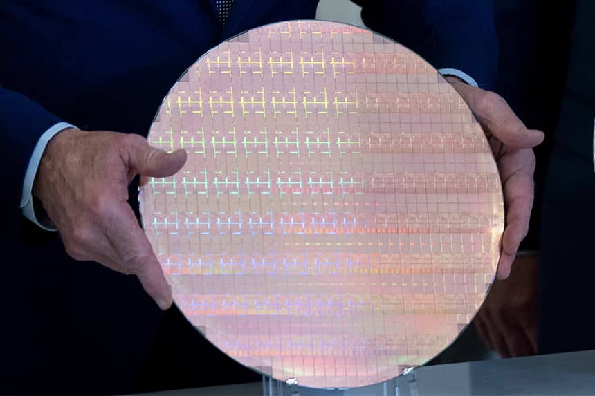 Joe Biden examina una oblea de semiconductores durante una visita al campus de Intel en Ocotillo, Chandler (Arizona), el 20 de marzo de 2024. (BRENDAN SMIALOWSKI/AFP a través de Getty Images)