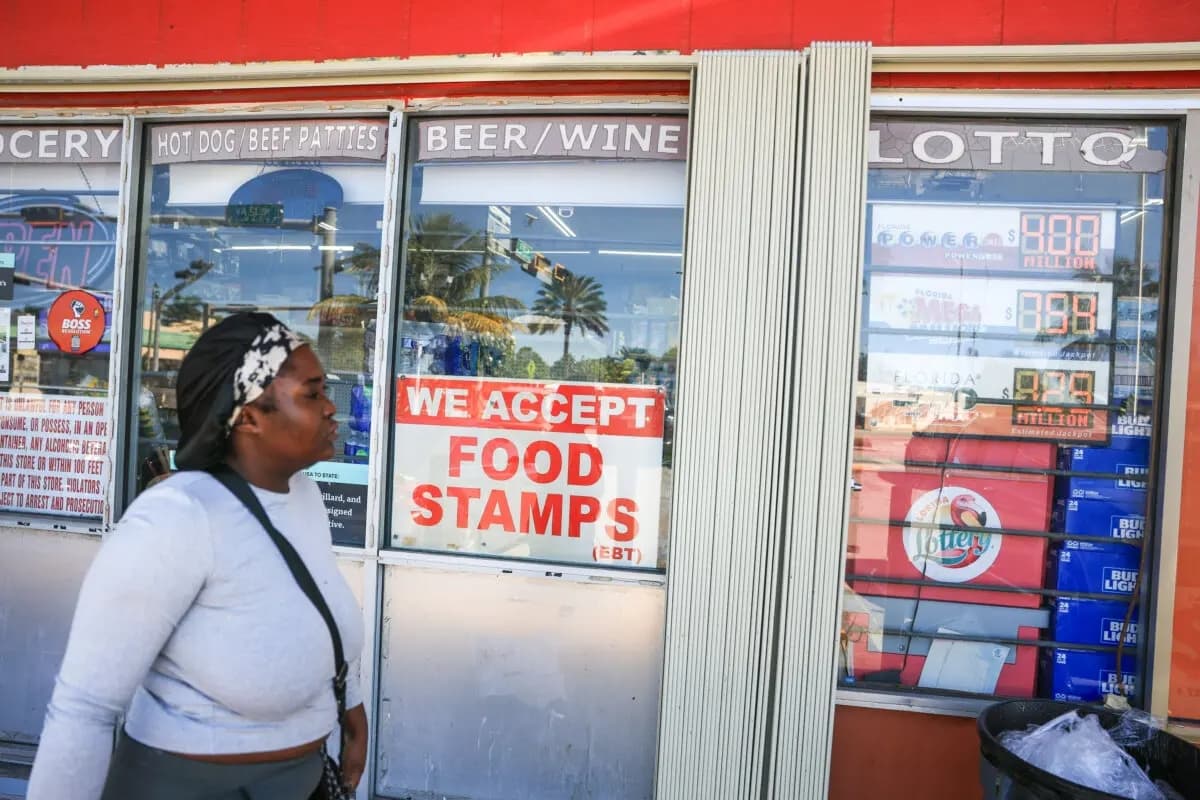 Una mujer pasa junto a un cartel que anuncia la aceptación de cupones de alimentos, en Miami, Florida, el 31 de octubre de 2025. (Joe Raedle/Getty Images)
