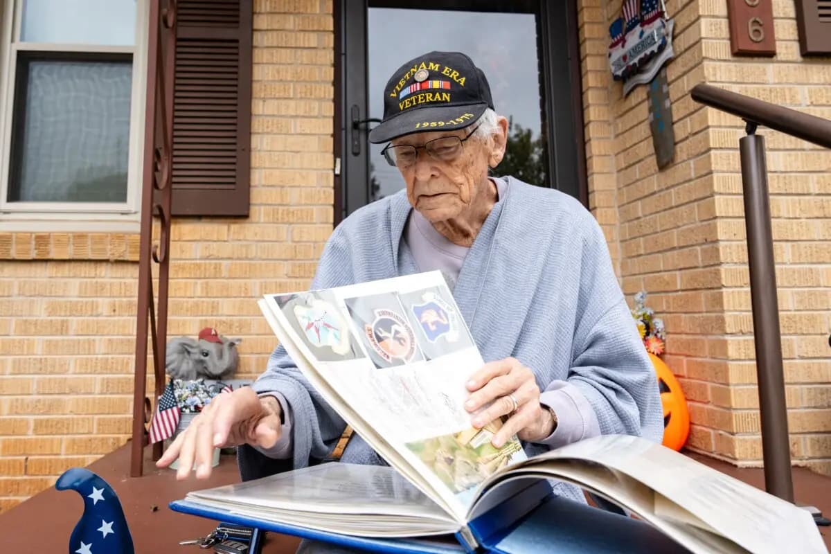 El veterano James Smith, de 90 años, mira su viejo álbum de fotos en Madison, Alabama, el 28 de octubre de 2025. (Samira Bouaou/The Epoch Times).