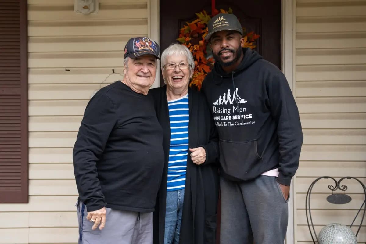 Rodney Smith Jr. (derecha), fundador de Raising Men Lawn Care Service, con Tom y Marguerite Weigand en Madison, Alabama, el 28 de octubre de 2025. (Samira Bouaou/The Epoch Times).