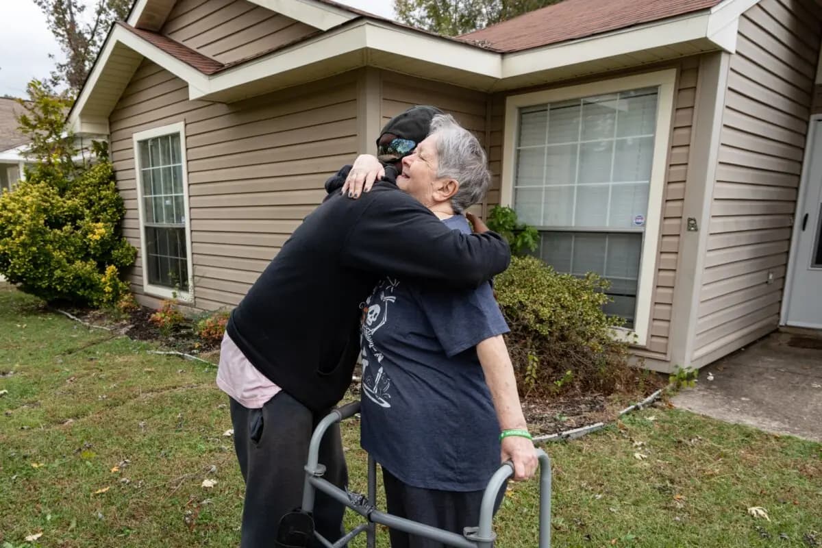 Rodney Smith Jr., fundador de Raising Men Lawn Care Service, abraza a Frances Helton en Madison, Alabama, el 28 de octubre de 2025. (Samira Bouaou/The Epoch Times).