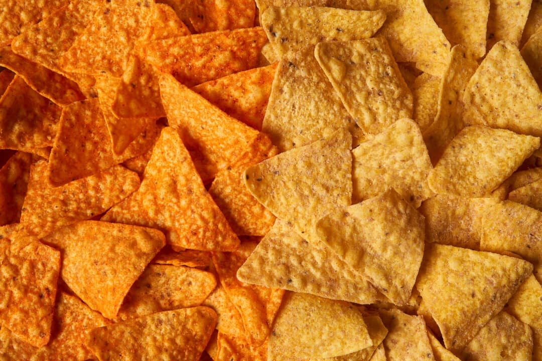 Esta imagen proporcionada por PepsiCo muestra, de izquierda a derecha, las papas fritas Doritos Nacho Cheese originales junto a los nuevos Doritos Simply NKD sin colorantes ni sabores artificiales. (PepsiCo vía AP)