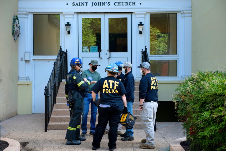 Miembros de la Oficina de Alcohol, Tabaco, Armas de Fuego y Explosivos (ATF) hablan frente a la iglesia Saint John's, que fue incendiada frente a la Casa Blanca, tras una tercera noche de violentas protestas por la muerte de George Floyd el 1 de junio de 2020 en Washington, D.C. (Foto de BRENDAN SMIALOWSKI/AFP a través de Getty Images)