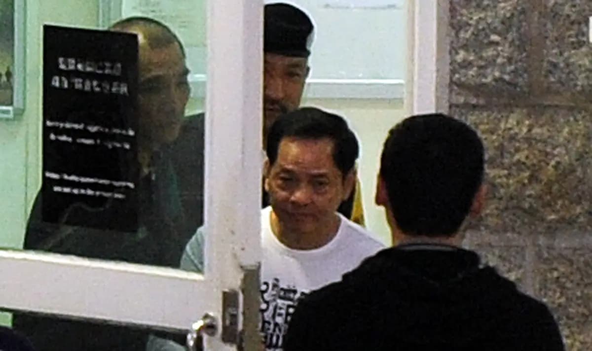 <em>Wan Kuok-koi (con camisa blanca), también conocido como "Broken Tooth", sale de una prisión en Macao el 1 de diciembre de 2012. (Laurent Fievet/AFP a través de Getty Images)</em>