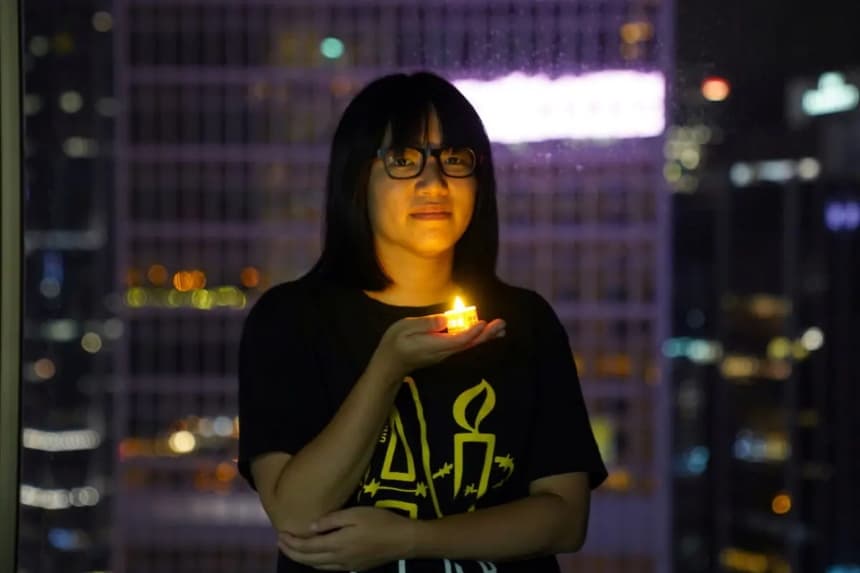 La vicepresidenta de la Alianza de Hong Kong en Apoyo a los Movimientos Democráticos Patrióticos de China, Chow Hang-tung, posa con una vela antes del 32.° aniversario de la masacre de manifestantes prodemocráticos en la plaza de Tiananmen de Beijing en 1989, en Hong Kong, el 3 de junio de 2021. (Lam Yik/Reuters)