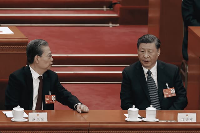El presidente chino, Xi Jinping, habla con el presidente de la Asamblea Popular Nacional, Zhao Leji, durante la quinta sesión plenaria de la Asamblea Popular Nacional, celebrada el 12 de marzo de 2023 en Beijing, China. (Lintao Zhang/Getty Images)