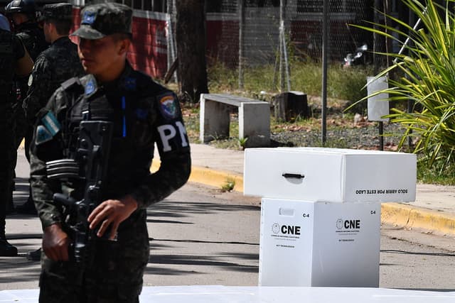 Un miembro de las fuerzas armadas custodia material electoral que será transportado a las regiones en Tegucigalpa el 20 de noviembre de 2025. Honduras celebrará elecciones presidenciales el 30 de noviembre. (Foto de Orlando SIERRA / AFP) (Foto de ORLANDO SIERRA/AFP vía Getty Images)