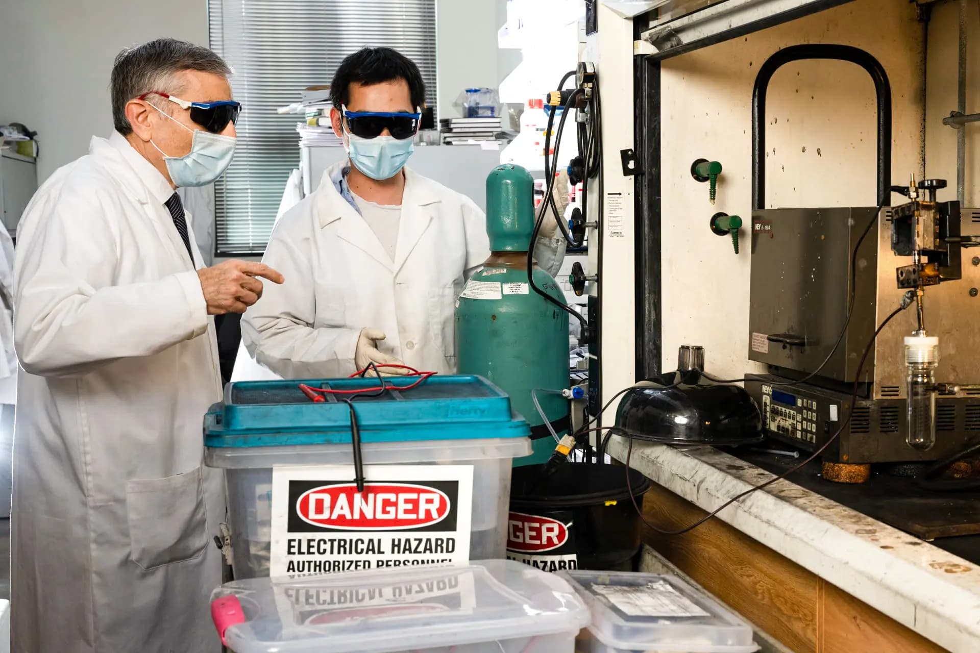 El químico James Tour (izquierda) y el investigador postdoctoral Bing Deng (derecha), ambos de la Universidad Rice, se preparan para "quemar" residuos electrónicos con el fin de recuperar sus valiosos metales para su reciclaje. El proceso del laboratorio, desarrollado inicialmente para convertir residuos alimenticios y otras fuentes de carbono en grafeno, se ha adaptado para recuperar otros materiales. (Jeff Fitlow/Universidad Rice).