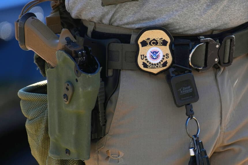 Se puede ver la placa y el arma de un agente del Servicio de Inmigración y Control de Aduanas (ICE) mientras el ICE lleva a cabo un control de vehículos en Georgia Ave. el 30 de agosto de 2025 en Washington, D.C. (Foto de Kevin Dietsch/Getty Images)