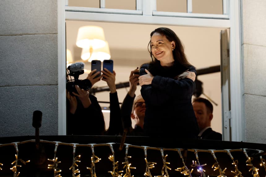 La ganadora del Premio Nobel de la Paz, María Corina Machado, saluda a sus simpatizantes desde un balcón del Grand Hotel en Oslo, Noruega, en la madrugada del 11 de diciembre de 2025. Machado llegó a Oslo horas después de que el galardón de la líder opositora venezolana fuera recogido en su nombre por su hija. (Odd ANDERSEN/AFP via Getty Images)