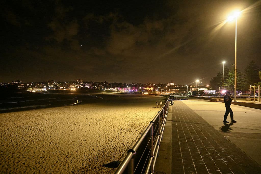 Un policía patrulla junto a la playa de Bondi tras un tiroteo ocurrido en Sídney el 14 de diciembre de 2025. (Saeed KHAN / AFP a través de Getty Images)