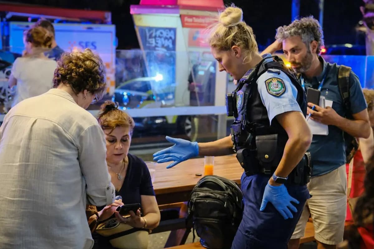 Los primeros oficiales de policía que acudieron al lugar hablan con los ciudadanos en la escena del tiroteo masivo en Bondi Beach, Sídney (Australia), el 14 de diciembre de 2025. (George Chan/Getty Images)