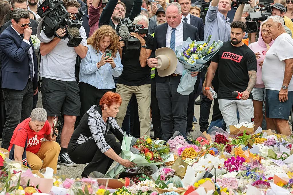 <em>La líder de One Nation, Pauline Hanson (abajo, C), deja flores frente al Bondi Pavilion en homenaje a las víctimas del tiroteo de Bondi Beach en Sídney, Australia, el 16 de diciembre de 2025. (David Gray/AFP vía Getty Images)</em>