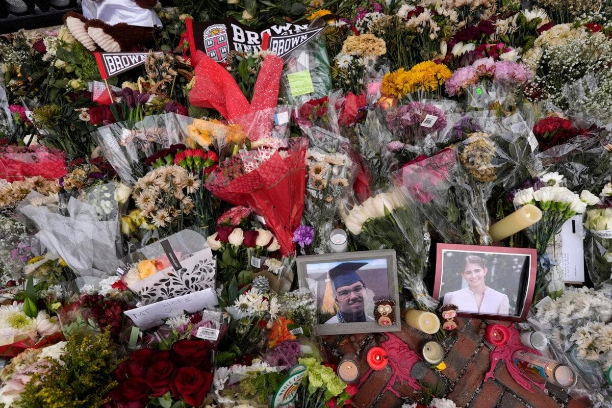 Fotos de las víctimas del tiroteo de la Universidad de Brown, Mukhammad Aziz Umurzokov (izquierda) y Ella Cook (derecha), entre flores en un memorial improvisado en la puerta Van Wickle de la universidad en Providence, Rhode Island, el 17 de diciembre de 2025. (Robert F. Bukaty/AP Photo)