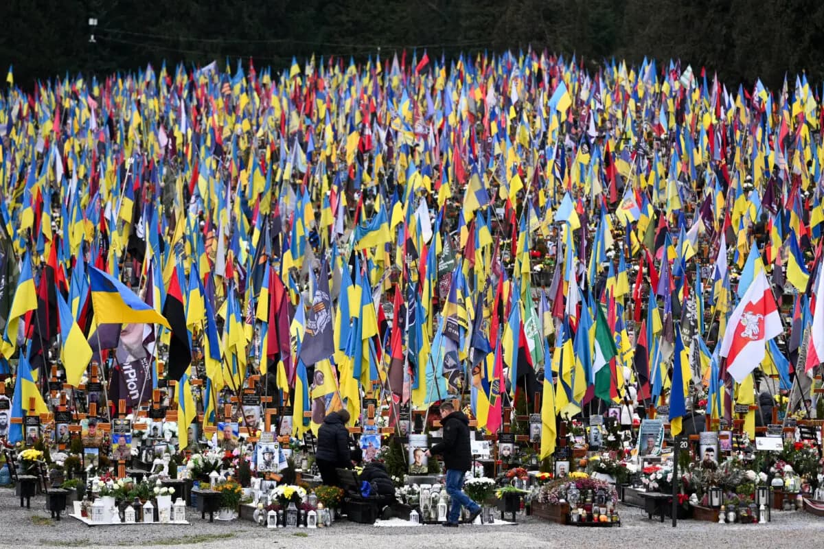 <em>Personas lloran ante las tumbas de los militares ucranianos en el cementerio de Lychakiv, en el Día de las Fuerzas Armadas de Ucrania, en Lviv, el 6 de diciembre de 2025. (Yuriy Dyachyshyn/AFP vía Getty Images)</em>