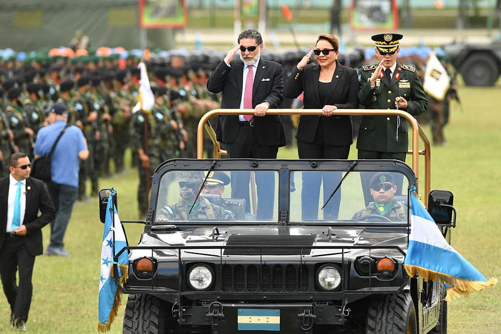 La presidenta de Honduras, Xiomara Castro, el viceministro de la Secretaría de la Defensa Nacional, Orlando Garner (izq.), y el jefe de las Fuerzas Armadas, general Roosevelt Hernández (der.), pasan revista a las tropas durante la celebración del bicentenario del Ejército hondureño en Tegucigalpa el 11 de diciembre de 2025. El ejército hondureño se comprometió el miércoles a garantizar una transferencia pacífica del poder, independientemente del ganador de las elecciones presidenciales del 30 de noviembre, en las que aún se están contando los votos en medio de acusaciones de interferencia. (Foto de Orlando SIERRA / AFP vía Getty Images)
