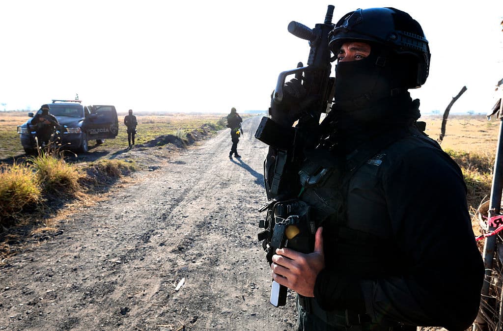 Miembros de la Fiscalía General de México vigilan la entrada a la carretera de un presunto «centro de reclutamiento» del crimen organizado en la comunidad de La Estanzuela, en el municipio de Tehuchitlán, estado de Jalisco, México, el 28 de marzo de 2025. (ULISES RUIZ/AFP vía Getty Images)