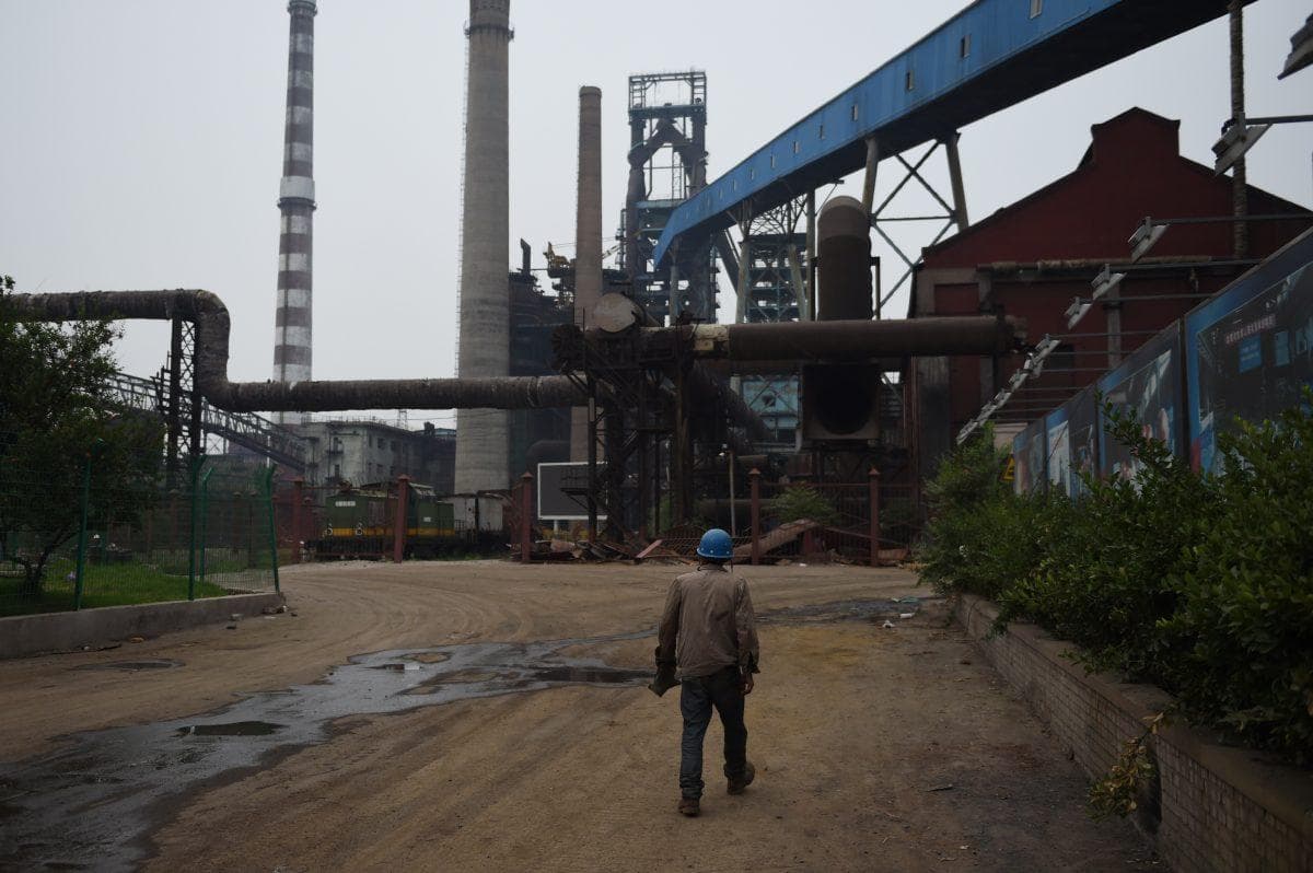 Un trabajador de demolición camina cerca de edificios abandonados en la planta siderúrgica Shougang Capital en Beijing el 28 de mayo de 2015. (Greg Baker/AFP/Getty Images)