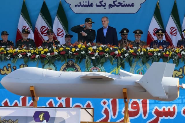 El presidente iraní, Masoud Pezeshkian (der.), y el comandante de la Fuerza Aeroespacial del Cuerpo de la Guardia Revolucionaria Islámica, Amir Ali Hajizadeh, observan la exhibición del nuevo dron iraní Shahed 136-B durante el desfile militar anual que conmemora el aniversario del estallido de la guerra de 1980-1988 contra el Iraq de Saddam Hussein, en Teherán, el 21 de septiembre de 2024. (ATTA KENARE/AFP vía Getty Images)