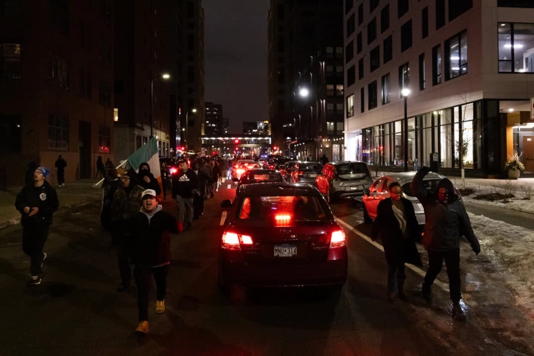 Manifestantes que protestan contra las operaciones del Servicio de Inmigración y Control de Aduanas (ICE) se enfrentan a oficiales de policía en Minneapolis, el 9 de enero de 2026. (John Fredricks/The Epoch Times)