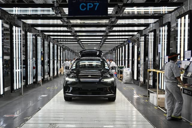 Empleados trabajan en una línea de producción de vehículos eléctricos (EV) en la fábrica de Leapmotor en Jinhua, provincia de Zhejiang, China, el 18 de septiembre de 2024. (Adek Berry/AFP a través de Getty Images)
