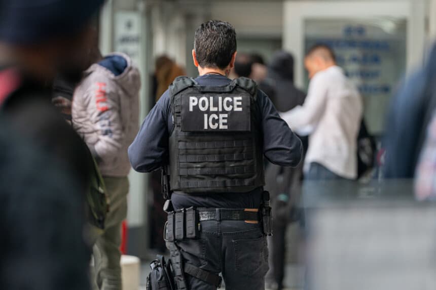 Un agente del ICE supervisa a cientos de solicitantes de asilo que están siendo procesados al entrar en el edificio federal Jacob K. Javits el 6 de junio de 2023 en la ciudad de Nueva York. La ciudad de Nueva York ha dado refugio a más de 46,000 solicitantes de asilo desde 2013, cuando aprobó una ley que prohíbe a los organismos municipales cooperar con las agencias federales de inmigración a menos que exista una orden de detención contra la persona. (Foto de David Dee Delgado/Getty Images).