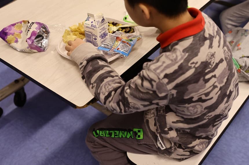 Un estudiante come una comida vegana servida para el almuerzo (con leche como bebida) en la escuela Yung Wing P.S. 124 el 4 de febrero de 2022 en la ciudad de Nueva York. (Michael Loccisano/Getty Images)