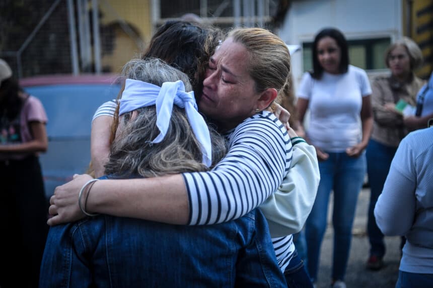 Familiares de detenidos se abrazan tras rezar frente a un centro de detención en Boleita mientras esperan la liberación de presos políticos el 12 de enero de 2026 en Caracas, Venezuela. (Carlos Becerra/Getty Images)