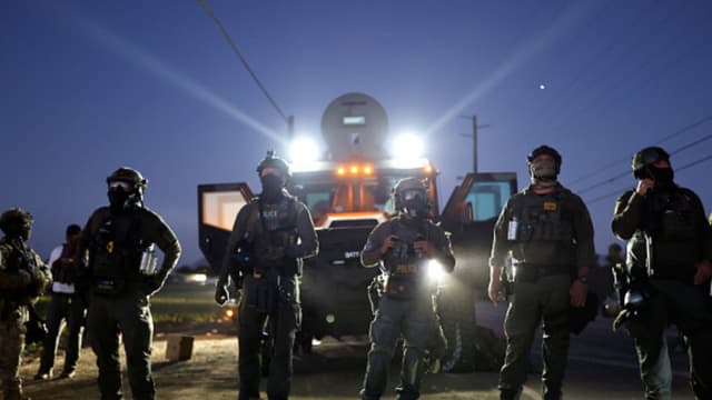 Agentes federales bloquean a personas que protestan contra una redada migratoria del ICE en una granja de cannabis con licencia cercana, el 10 de julio de 2025, cerca de Camarillo, California. Los manifestantes se enfrentaron durante horas a los agentes federales frente a la granja, situada en la comunidad agrícola del condado de Ventura. Un juez federal de Los Ángeles dictará sentencia el viernes sobre una orden de restricción temporal que limitaría las operaciones de control migratorio en la zona. (Foto de Mario Tama/Getty Images).