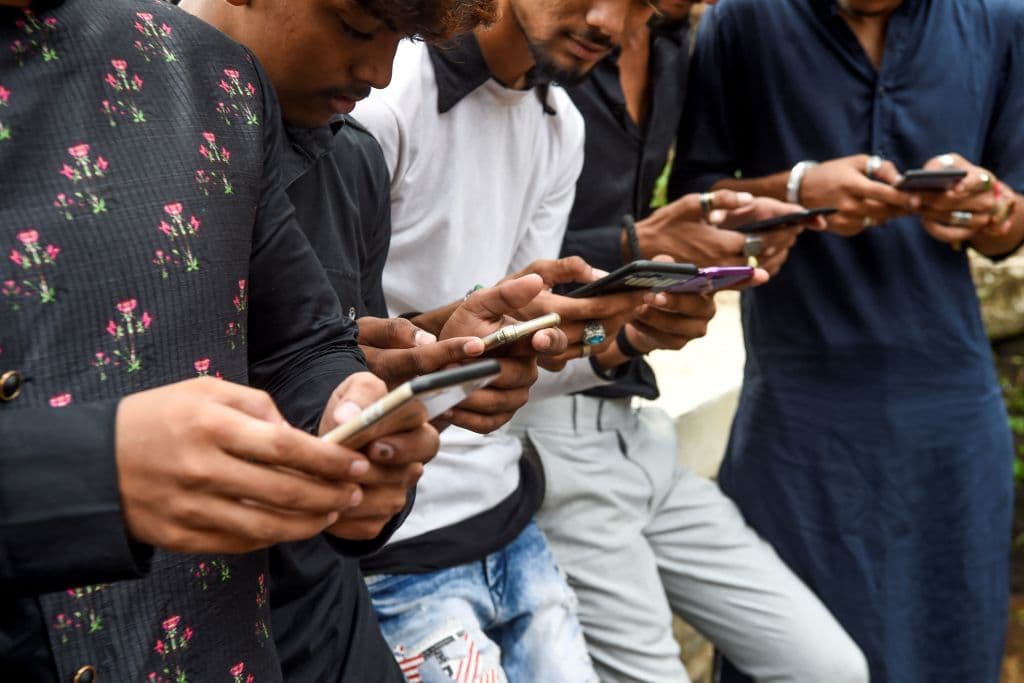 En esta foto tomada el 10 de noviembre de 2019, unos jóvenes ven vídeos en la aplicación para compartir vídeos TikTok en sus teléfonos móviles en Bombay. (Foto de Indranil MUKHERJEE / AFP) (Foto de INDRANIL MUKHERJEE/AFP a través de Getty Images)