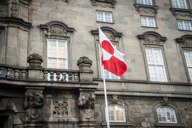 La bandera groenlandesa, llamada "Erfalasorput", ondea junto a la entrada principal del Parlamento danés, Christiansborg, en Copenhague, Dinamarca, el 16 de enero de 2026. Se programó una reunión de políticos groenlandeses, daneses y estadounidenses para ese mismo día. (Sebastian Elias Uth/Ritzau Scanpix/AFP vía Getty Images)