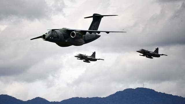 Un piloto de la Fuerza Aérea Brasileña con su avión Embraer C-390 Millennium, escoltado por dos cazas Saab JAS 39 Gripen, realiza una presentación durante la exhibición aérea F-Air Colombia 2025 en Rionegro, Antioquia, Colombia, el 11 de julio de 2025. (Foto: JAIME SALDARRIAGA/AFP vía Getty Images)