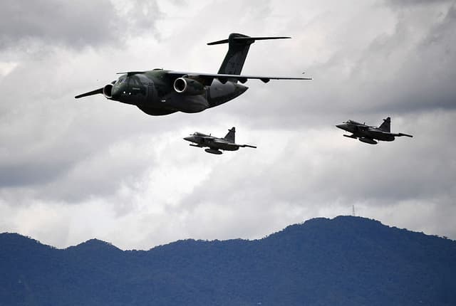 Un piloto de la Fuerza Aérea Brasileña con su avión Embraer C-390 Millennium, escoltado por dos cazas Saab JAS 39 Gripen, realiza una presentación durante la exhibición aérea F-Air Colombia 2025 en Rionegro, Antioquia, Colombia, el 11 de julio de 2025. (Foto: JAIME SALDARRIAGA/AFP vía Getty Images)