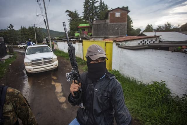 Hombre armado en las plantaciones de aguacate, azotadas por los cárteles de la droga que dominan la zona, en Ario de Rosales, estado de Michoacán, México, el 8 de julio de 2021.  (ENRIQUE CASTRO/AFP vía Getty Images)