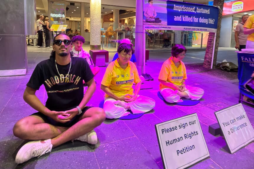 Los transeúntes se unen a una meditación con practicantes locales de Falun Gong en Cavill Mall, en Gold Coast, Australia, el 2 de enero de 2026. (Cortesía de Maryann Leatham).